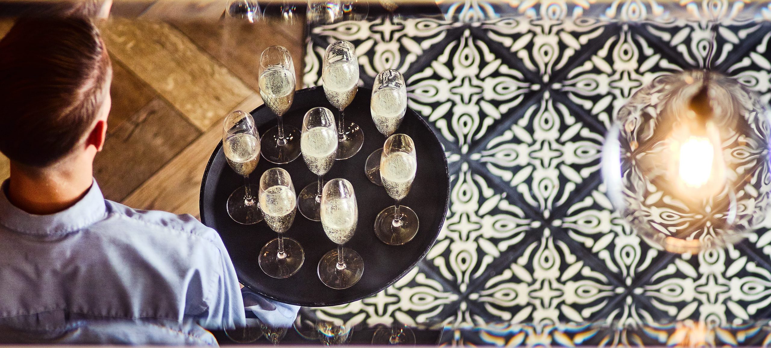 Côte, waiter carrying tray of champagne flutes