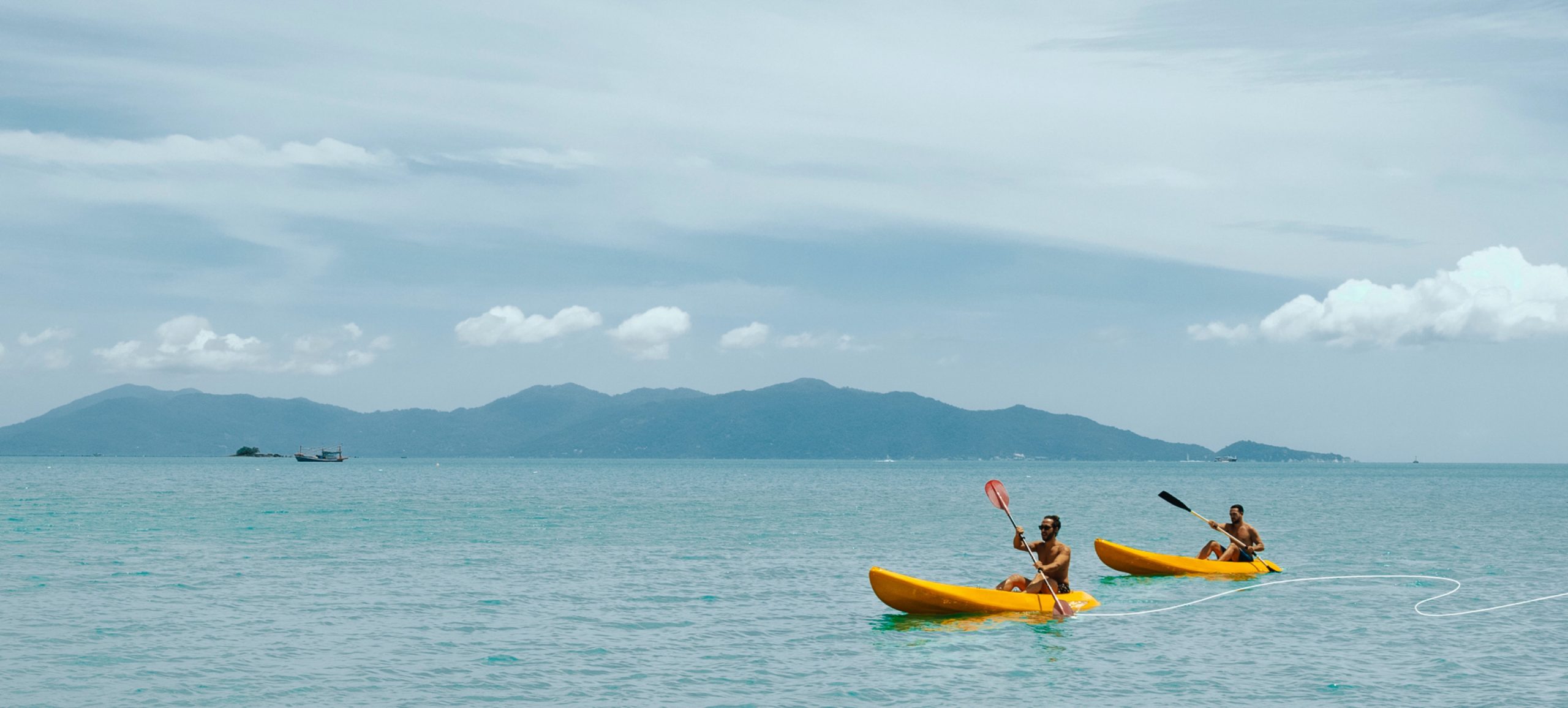 Small Luxury Hotels of the World, SLH, the doodle graphic embellishment that connects the imagery to the brand. Two people in yellow canoes